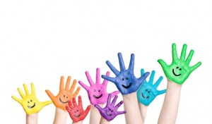 lachende Kinderhände in regenbogenfarben
